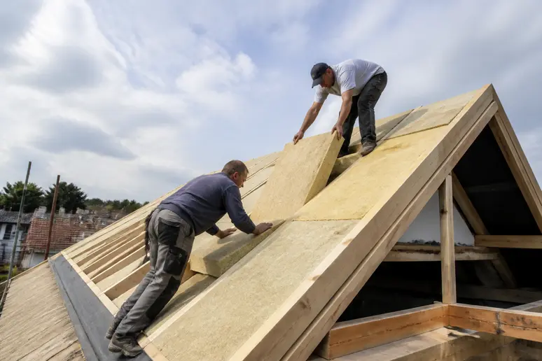 Pose de panneaux d'isolation thermique sur la charpente d'une toiture en rénovation
