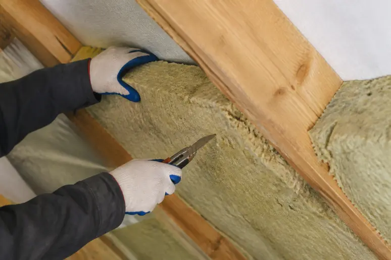 Découpe précise d'un panneau d'isolant thermique pour une pose entre chevrons de toiture par l'intérieur