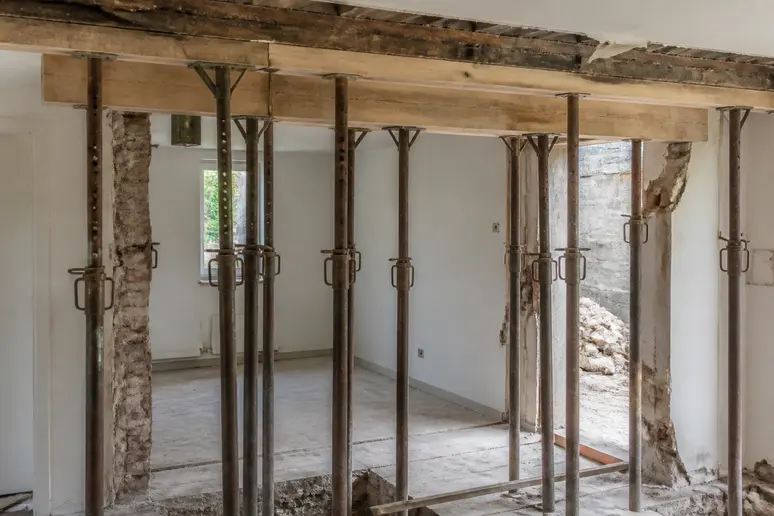 Mise en place d'étais métalliques pour sécuriser le chantier lors de l'ouverture d'un mur porteur.