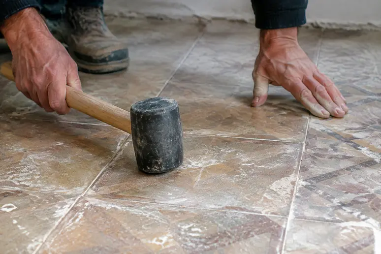 Vérification de l'adhérence d'un ancien carrelage avant de poser un nouveau revêtement de sol.