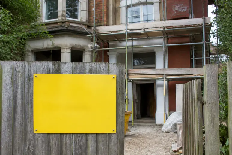 Panneau de déclaration préalable de travaux affiché sur un chantier d'extension de maison.