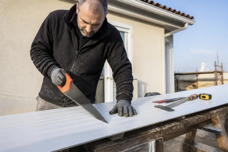 Ajustement des lames de lambris PVC sous toiture pour adapter la pose aux dimensions de la rive