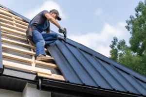 Un artisan pose des tôles métalliques de toiture pour illustrer le prix toiture bac acier au m2 sur un chantier.