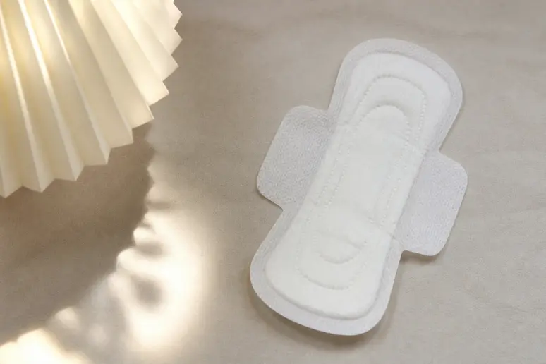 Serviette hygiénique propre posée sur une surface neutre pour surveiller un écoulement suspect